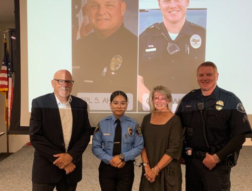 A group of people standing in front of a picture.