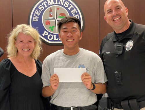 A man holding a cheque in front of two police officers.