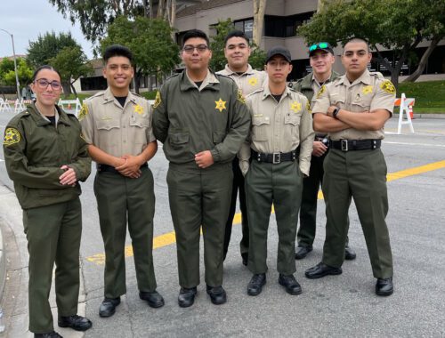 A group of people in uniform standing on the side walk