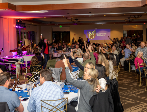 A crowd of people sitting at tables in a room.