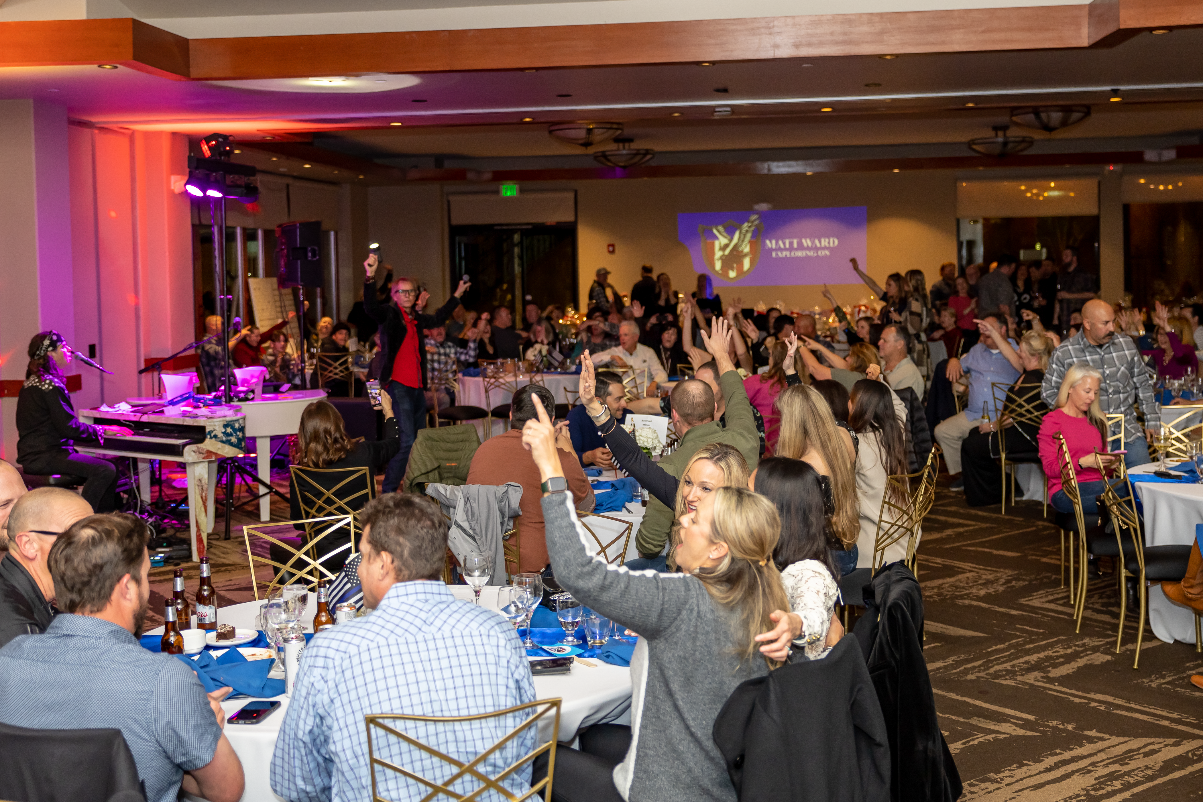 A crowd of people sitting at tables in a room.