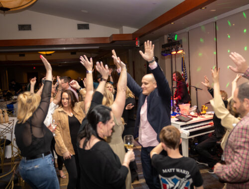 A group of people raising their hands in the air.