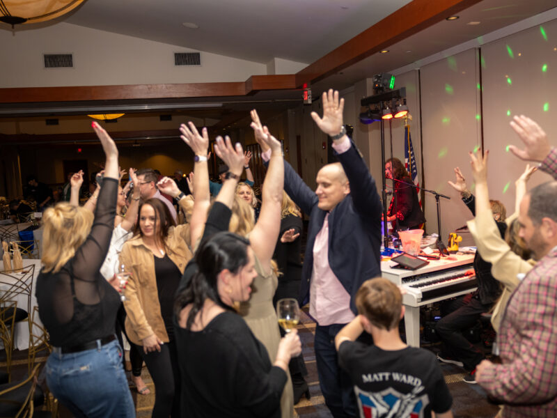 A group of people raising their hands in the air.