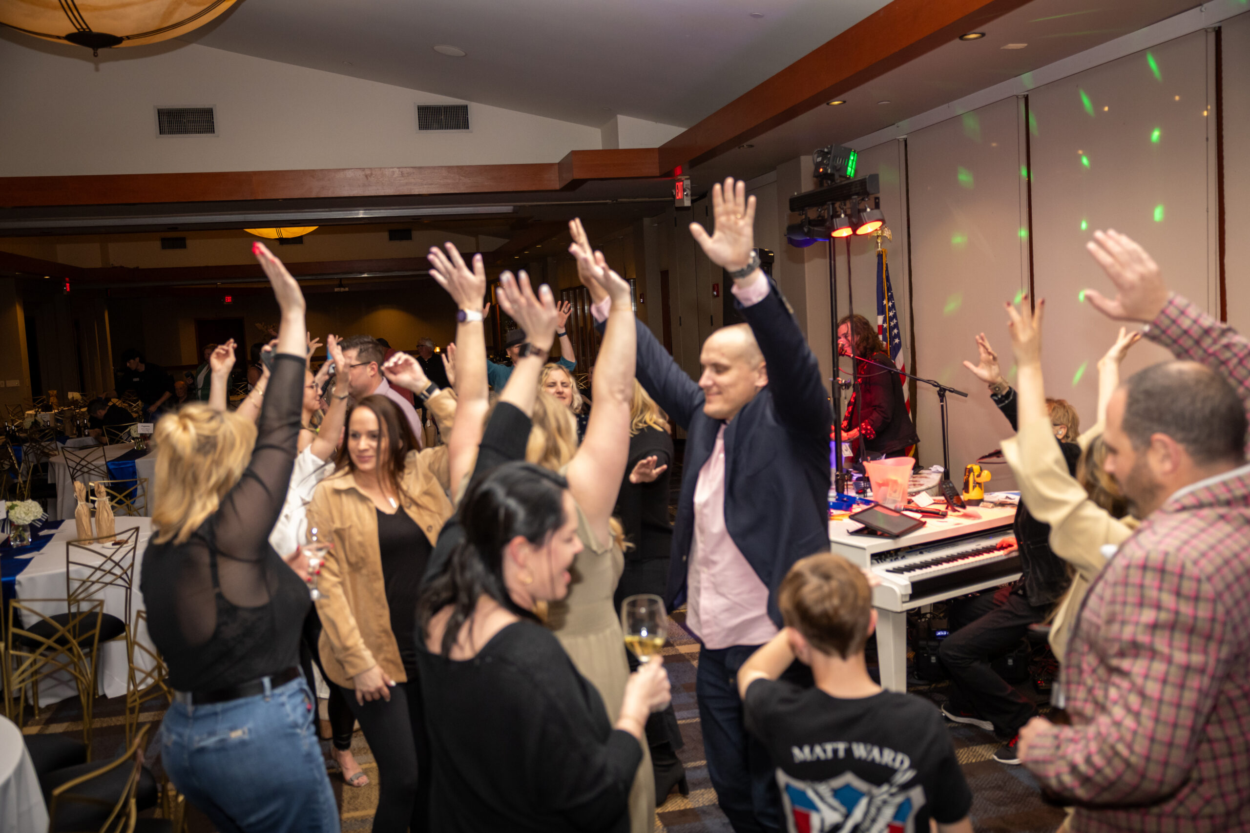 A group of people raising their hands in the air.